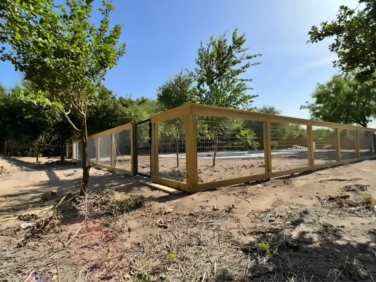 Custom fence with 6 gauge horse panel wire, wood posts and a heavy duty gate built for a dog training facility in McAllen, Texas