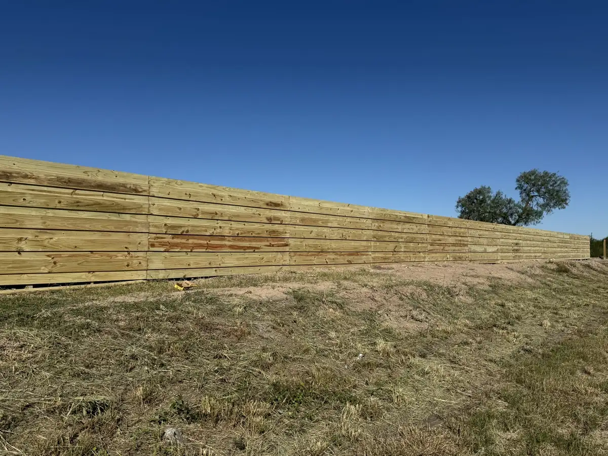Long horizontal wood privacy fence installed along a rural Rio Grande Valley property
